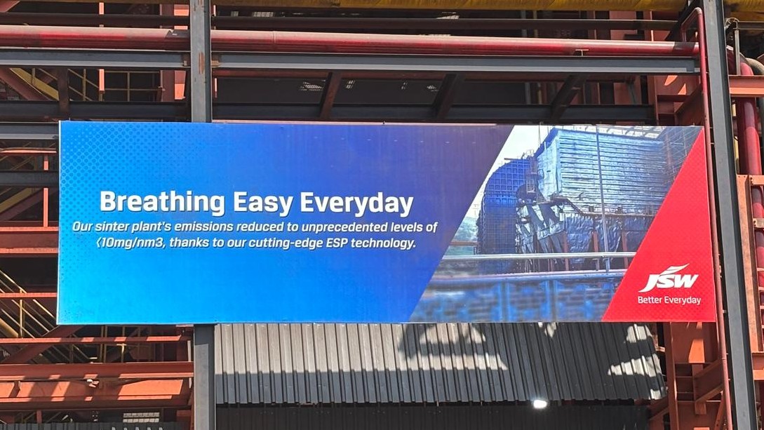 JSW Vijayanagar Metallics billboard celebrating sinter plant ESP emission performance, displayed at the steelworks
